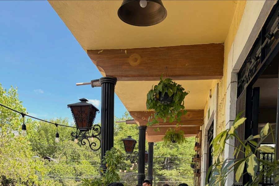 Terraza de Estación 31 en Tequisquiapan: faroles de herrería, plantas colgantes y columnas sobre el Parque La Pila